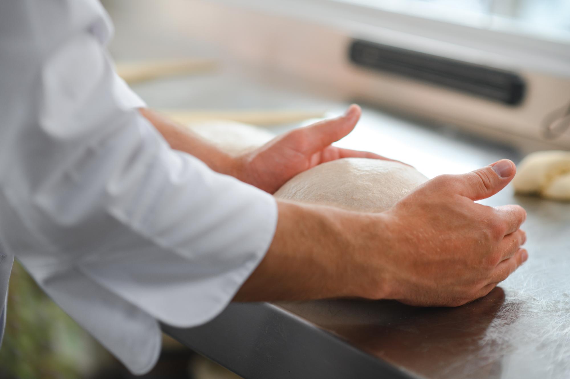 Close-up of hands kneading dough